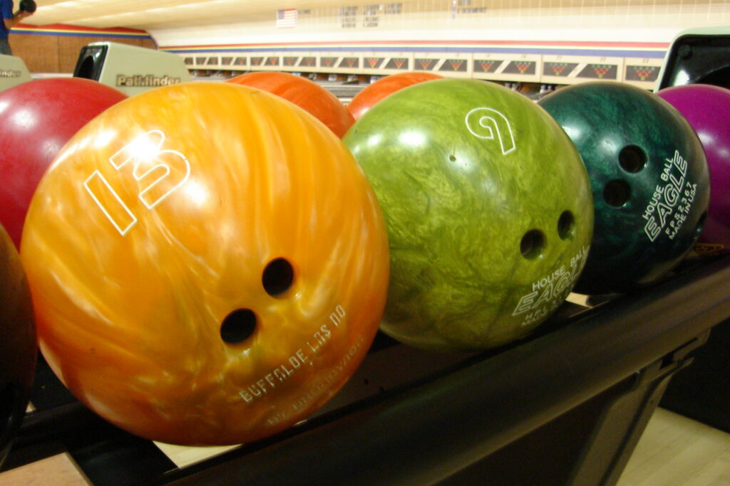 这张图片是几个彩色的球在一个碗返回。保龄球的形状是完美的贴合之间的标准空间和瓶。