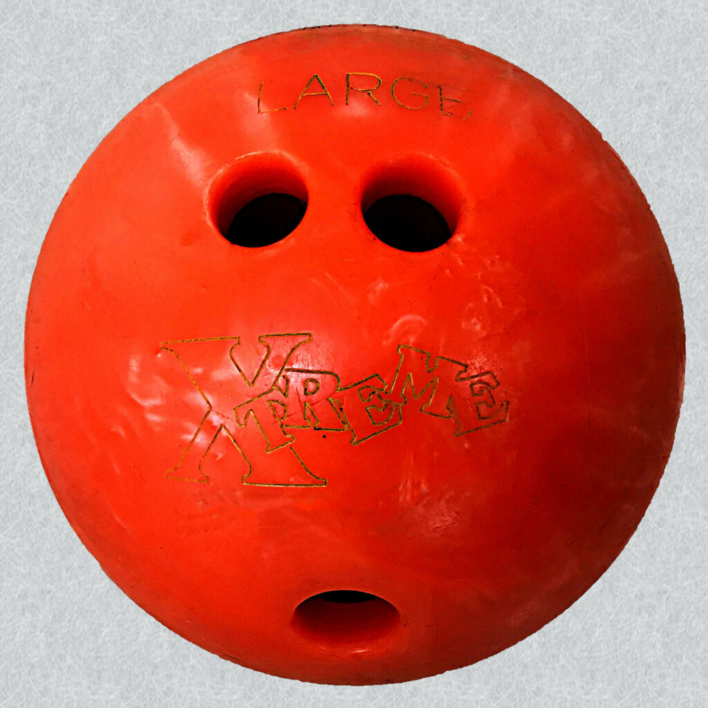 橙色的橡胶保龄球上面刻有“大”字的大手指洞。